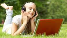 Eine Frau hört Musik auf einer Wiese (Foto: Colourbox)