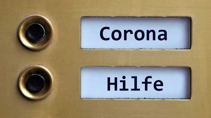 Auf einem Klingenschild stehen die Wörter Corona und Hilfe (Foto: imago images/Steinach)