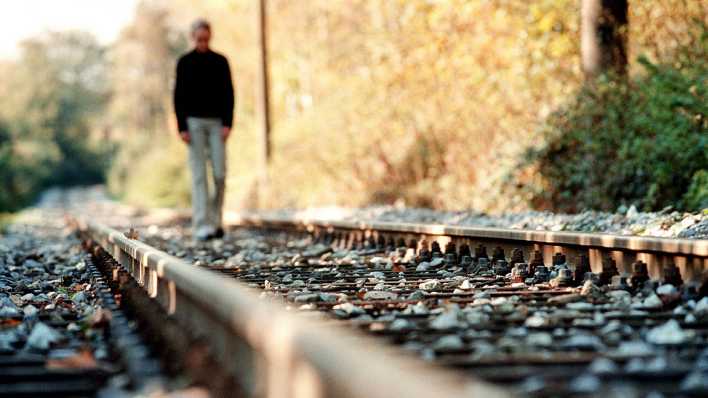 Ein Mann läuft auf Bahnschienen (Foto: imago images/Marco Stepniak)