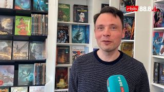 Ein Mann steht vor einem Regal mit Comic-Büchern (Foto: rbb 88.8)