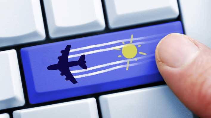 Finger auf Computertaste mit Flugzeugsymbol, , Foto: imago/Christian Ohde