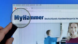 Eine Lupe ist auf die Website des handwerkerportals von myhammer.de gerichtet (Foto: imago stock&people/Schöning)