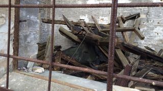 Hinter einem Gitter liegt ein Holzstapel (Foto: radioBERLIN 88,8 / Doris Anselm)