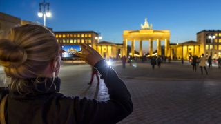 Eine Frau fotografiert das Brandenburger Tor in Berlin (Foto: imago images/Joch Tack)