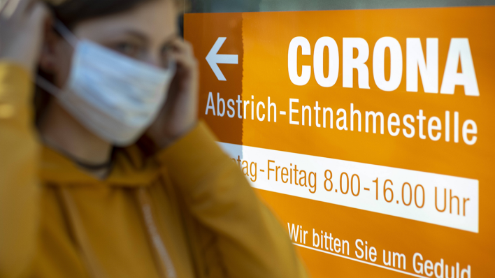 Eine Frau mit Maske steht vor einer Corona-Teststelle in Berlin (Foto: imago images/photothek)