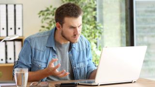 Ein Mann sitzt vor einem Laptop und ärgert sich (Foto: imago images/Panthermedia)
