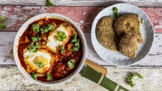 Eine Pfanne mit Shakshouka und Naan-Brot auf einem Teller (Bild: imago/Sandra Roesch)